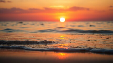 Fototapeta premium Sunset paints the ocean with hues of orange and red, as the sun dips below the horizon