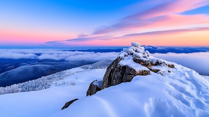 Sunrise over snowy mountain peak with clouds