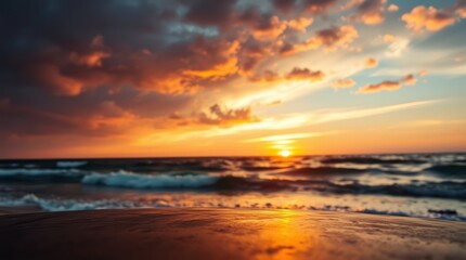 Golden light paints the sky as the sun dips below the horizon, casting a warm glow on the ocean waves lapping the sandy beach
