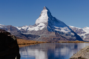 Majestic snow-capped peak reflected in a still lake.