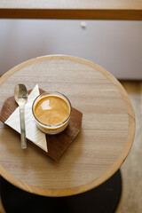 Cup of milk dirty coffee on table by the window.