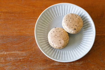 Brown orange Ceylon black tea flavor macaron on wooden table.