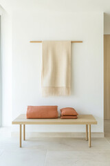 Minimalist interior design featuring a wooden bench and textile accents in a bright room
