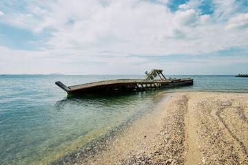 Fishing boat rests on the sandy shore, a silent testament to the ocean's power and the passage of time