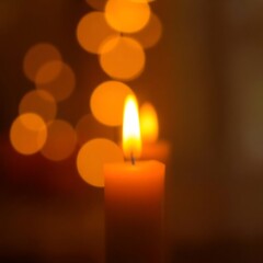 Lit candle with bokeh lights.