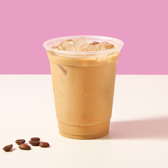 A glass of iced cafe late in a transparent plastic mug, on a white and pink background                                                                    