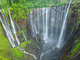 Amazing aerial view Many streams of water flow down in all directions and fall at Tumpak Sewu...