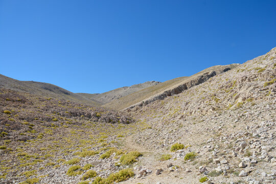 Hiking trail on the southern part of the island of Krk in Croatia defined by a barren, rocky terrain dotted with patches of resilient vegetation