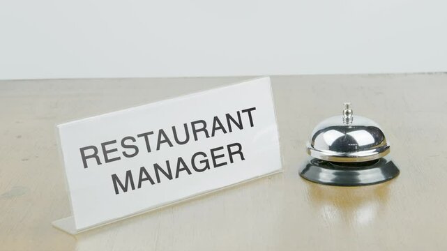 Restaurant manager Office or Room with Hand Ringing The Bell on Desk or Table Multiple Times