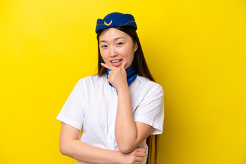 Airplane Chinese woman stewardess isolated on yellow background smiling