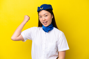 Airplane Chinese woman stewardess isolated on yellow background doing strong gesture