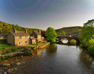 Fototapeta premium A river with a bridge in a European countryside setting, with mountains in the background.