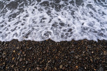 Water sea beach. Wave ocean blue. Stone texture reflection sun. Surface coast pebbles. 