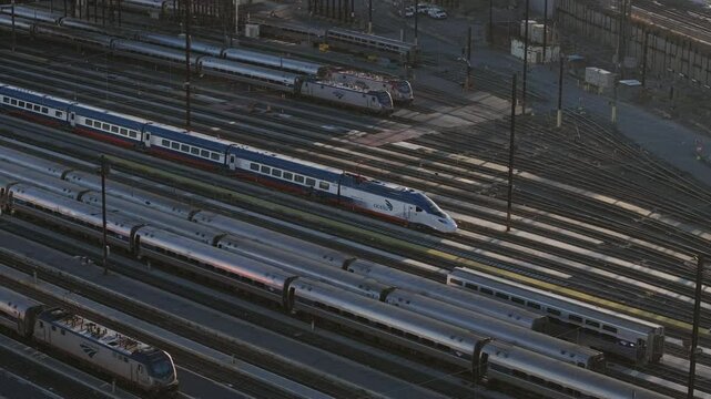 Elevated view of Amtrak train parked in a New York City railway station, highlighting metropolitan transit network and commuter movement patterns