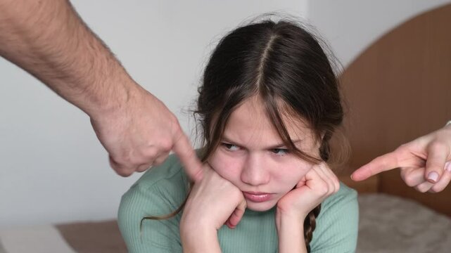 Parents scolding little girl at home. Sad kid ignoring them. Child having bad mood and feeling upset. Family conflict