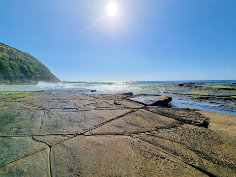 Rock platform at Susan Gilmore Beach Newcastle, New South Wales, Australia. At low tide with waves crashing against the rock