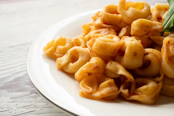 Tortellini with tomato sauce on a white plate