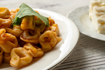 Tortellini with tomato sauce on a white plate