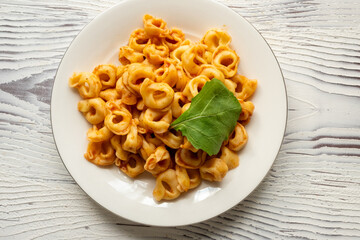 Tortellini with tomato sauce on a white plate