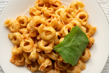 Tortellini with tomato sauce on a white plate