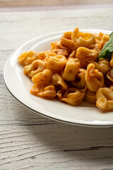 Tortellini with tomato sauce on a white plate