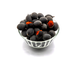 A bowl of velvet tamarind (Dialium indum) or kranji in Indonesia isolated on a clean white background