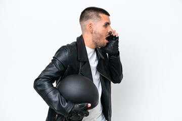 Naklejka premium Young caucasian man with a motorcycle helmet isolated on white background shouting with mouth wide open to the side