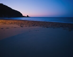 Obraz premium Peaceful Ocean Waves Rolling onto the Sandy Coast at Dusk