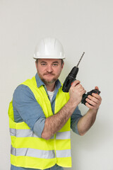 worker with a drill in his hands on a white background. concept of being ready for any job.