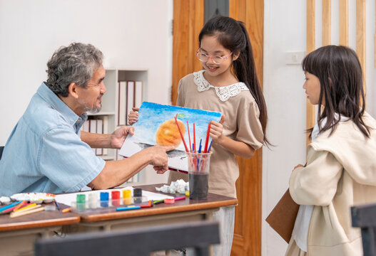 teen girls enjoy drawing watercolors with a senior experienced teacher,elementary students learning new skill of art during school break - Powered by Adobe