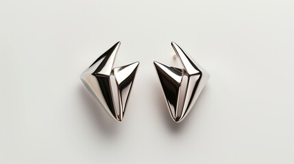 A pair of sleek, modern earrings with a geometric design, showcased on a white backdrop.