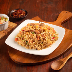 delicious fried rice with vegetables pickles in a wood background