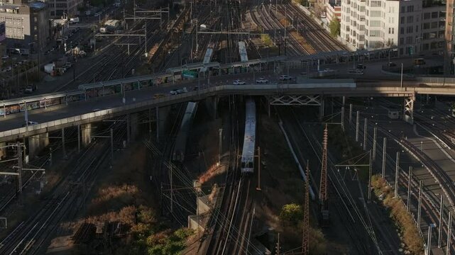 Metropolitan subway train navigating elevated railway, spanning sprawling trainyard with New York City's transit system under sunlit sky