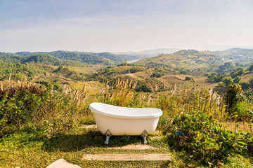Peaceful Mountainside Retreat - A bathtub offers a peaceful escape on a mountainside, surrounded by...