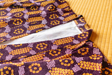 Japanese haori jacket with purple and orange pattern placed on tatami mats.