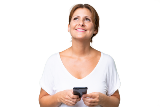 Middle-aged caucasian woman over isolated background using mobile phone and looking up