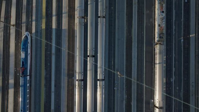 Aerial perspective capturing passenger trains parked in a bustling New York City rail station, neighboring stationary train on parallel tracks