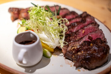 Medium rare wagyu meat served on plate with sauce and vegetable