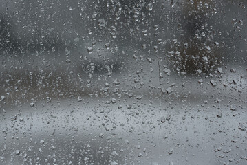 WET WEATHER - Raindrops running down the glass wall