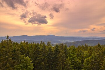 A view to the mountains Bobik and Boubin of Sumava National Park from lookout tower Libin in closing sunset