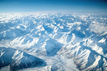 Fototapeta premium Aerial view of a snow-covered mountain range stunning landscape photography majestic winter environment high altitude perspective nature's beauty captured in the skies