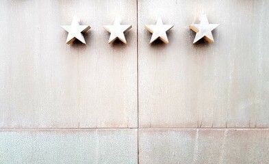 Five white wooden stars on the wall of a building in the form of a star