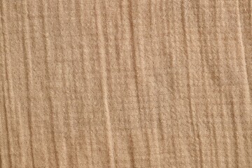 Texture of crumpled linen fabric under natural light in peach fuzz color