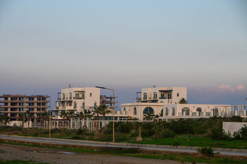 Modern architecture meets coastal serenity in a developing seaside community at dusk