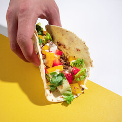 beef and mixed vegetable on a flour tortilla wrap, on a yellow vibrant background.