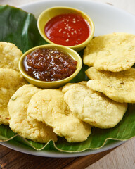 indonesian traditional aci goreng, known as cireng or fried tapioca, on top of banana leaves in a white wooden background.