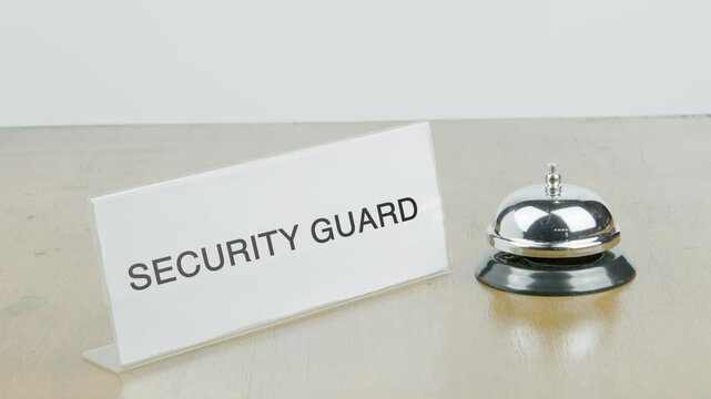 Security guard Office or Room with Hand Ringing The Bell on Desk or Table Multiple Times