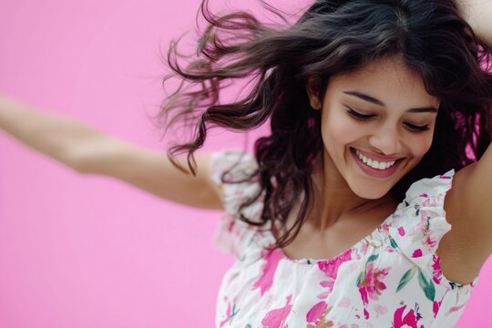 A woman smiles while holding her hair up, capturing a moment of joy