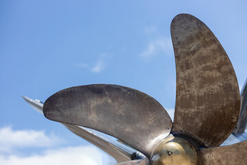 Close-up of a boat propeller against a blue sky. © Margo Alexa