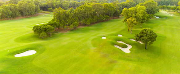 An aerial view of a golf course with sand traps and lush greenery